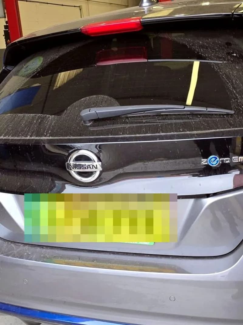 The rear of a Nissan Leaf electric car inside the workshop, showing its zero emission badge.